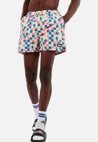 Bañador con un colorido patrón de ajedrez en tonos pastel, una cinturilla elástica con cordón y un parche de logo de marca en negro.