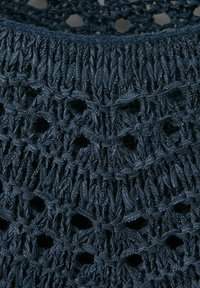 Donkerblauwe gebreide stof met een ingewikkeld openwerkpatroon en gevarieerde steektexturen die geometrische vormen creëren.