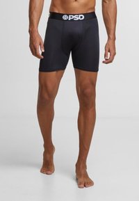 Boxers en modal noir avec une coupe ajustée, dotés d'une ceinture élastique douce avec le logo "PSD" en blanc. Texture lisse, coupe longueur genou.