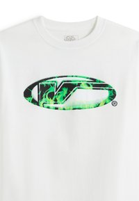 T-shirt en coton blanc avec un grand logo orné d'accents de flammes vertes et d'un contour noir. Le motif est centré à l'avant.