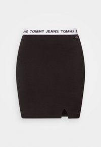 Gonna nera aderente con una cintura elastica bianca stampata con "TOMMY JEANS." Presenta una piccola apertura all'orlo. Tessuto dal tocco liscio.