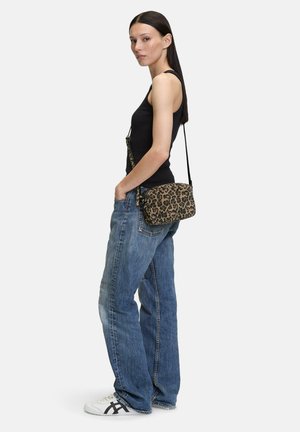 Borsa a spalla con stampa leopardata e chiusura con zip, realizzata in tessuto testurizzato, abbinata a una canotta nera attillata e jeans blu rilassati.