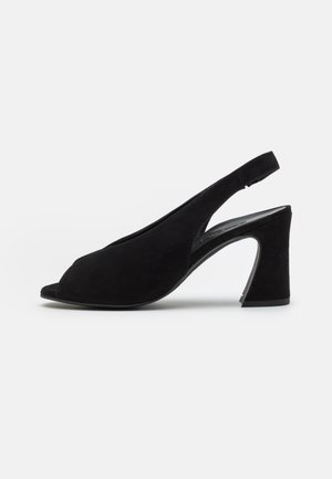 Sandale à talon slingback en daim noir avec bout ouvert et talon carré sur fond blanc.