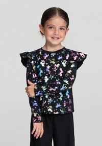 Czarna koszula z długim rękawem z tęczowym wzorem jednorożców i gwiazd, z falbanami na rękawach i okrągłym dekoltem. Miękki, elastyczny materiał.