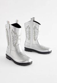 Silberne Cowboy-Stiefel mit Prägeblattmustern, Gummisohlen und Zuglaschen. Sie verfügen über ein glänzendes Finish und dekorative Nähten am Schaft.