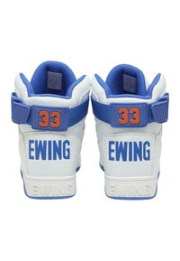 Biele a modré vysoké tenisky s textúrovanou podrážkou, s označením "Ewing" v modrej a oranžovej farbe a polstrovaným golierom pre podporu.