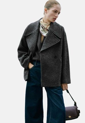 Grå uld peacoat med store revers, dobbeltknaplukning og en afslappet pasform, parret med vidde jeans i mørk denim og et mønstrede tørklæde.