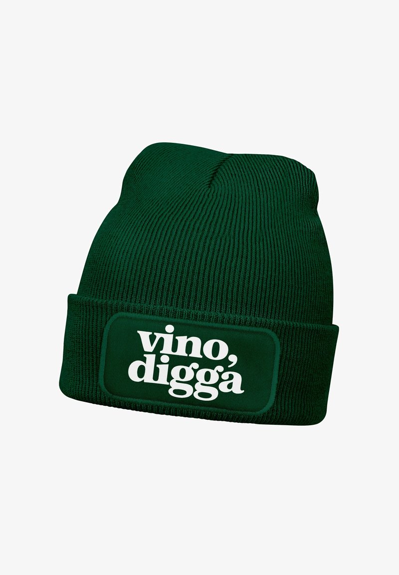 Green knitted beanie with a folded cuff displaying a rectangular patch that reads “vino, digga” in bold white text.