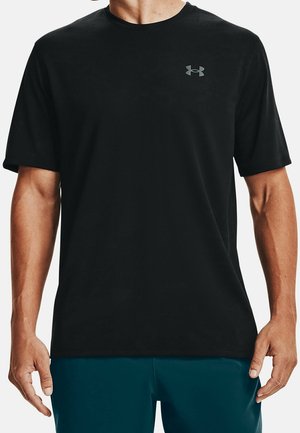 Man draagt een zwart sport-T-shirt met korte mouwen en een klein grijs Under Armour-logo op de borst, gecombineerd met donkerblauwe shorts.