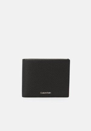 Schwarze Lederbörse mit strukturiertem Finish, mit einem silbernen Calvin Klein-Logo am unteren Rand. Rechteckige Form mit minimalistischem Design.