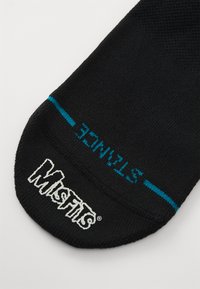 Black sock featuring a blue stripe and "STANCE" text. The Misfits logo is embroidered in white on the top. Material appears smooth and stretchy.