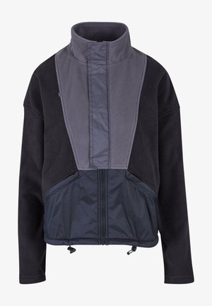 Polárdzseki magas gallérral, szürke elülső panellel és fekete testtel. Cipzáras elülső rész és állítható szegély zsinórral.