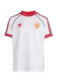 Bijela nogometna majica s crvenim akcentima, s rebrastim ovratnikom i prugastim rukavima. Sadrži logo Manchester Uniteda i Adidasovu oznaku.