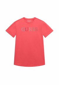 T-shirt a maniche corte color corallo realizzato in cotone con scollo rotondo. Presenta un logo "GUESS" scintillante sulla parte anteriore in cristalli colorati.