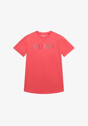 T-shirt a maniche corte color corallo realizzato in cotone con scollo rotondo. Presenta un logo "GUESS" scintillante sulla parte anteriore in cristalli colorati.