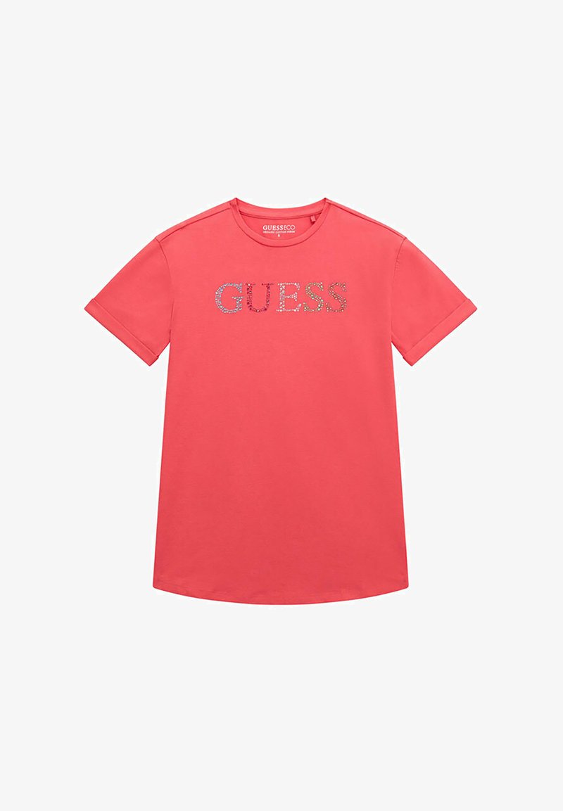 T-shirt a maniche corte color corallo realizzato in cotone con scollo rotondo. Presenta un logo "GUESS" scintillante sulla parte anteriore in cristalli colorati.