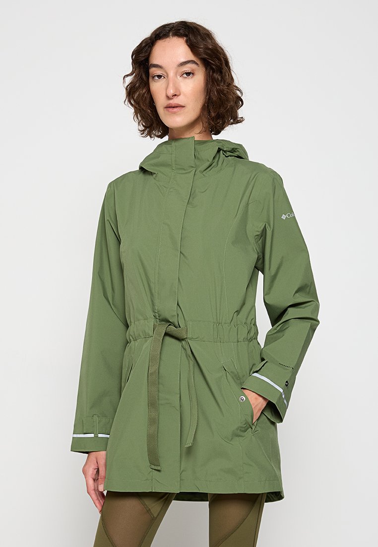 Oliwkowa kurtka przeciwdeszczowa z wcięciem w talii, kapturem i odblaskowymi akcentami. Posiada boczne kieszenie oraz gładką, lekką fakturę.