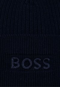 Granatowa dziana czapka z teksturowanej tkaniny, z prążkowanym wzorem, z haftowaną nazwą marki "BOSS" w dopasowanym kolorze.