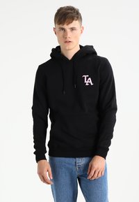 Zwarte hoodie met een voorzak en trekkoord. Voorzien van een roze "LA" logo op de linkerborst. Gemaakt van een zachte stof.