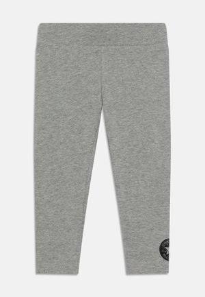 Leggings grigi con una superficie liscia, design aderente e un logo circolare nero sulla gamba inferiore. Vita elasticizzata per comfort.