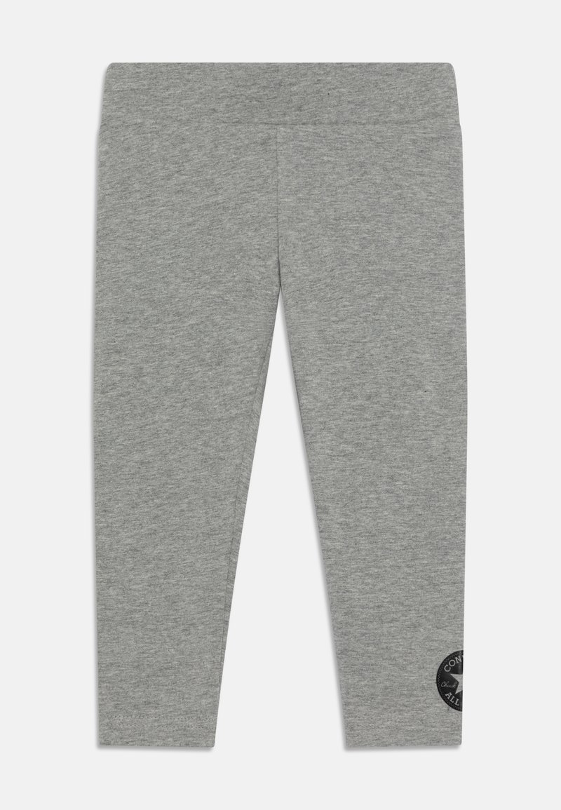 Szürke leggings sima textúrával, testhezálló kialakítással és fekete kör alakú logóval az alsó lábszáron. Rugalmas derekú a kényelem érdekében.