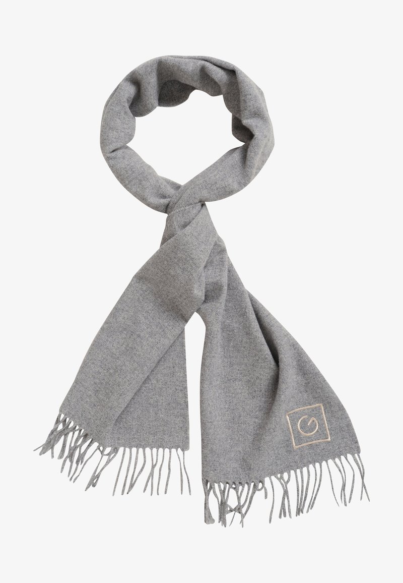 Écharpe douce en laine gris clair avec des extrémités à franges et un petit logo carré cousu sur un côté, présentée en boucle et bien arrangée.