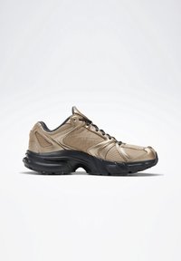 Baskets de sport beige et noires avec dessus en mesh et synthétique, fermeture à lacets, et semelle épaisse texturée, vues de profil droit sur fond blanc.