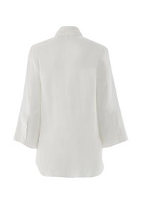 White linen blouse with three-quarter sleeves, a collar, and a smooth texture. Features a loose fit with side slits for added comfort.