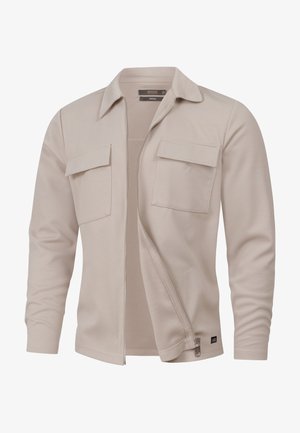 Beige jakke med lynlås lavet af struktureret stof, med to brystlommer, spidst krave og et slankt design.