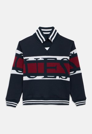 Mornarska majica s visokim ovratnikom, sa upečatljivim crveno-bijelim prugastim dizajnom i istaknutim natpisom "QUE", te rebrastim manžetnama.