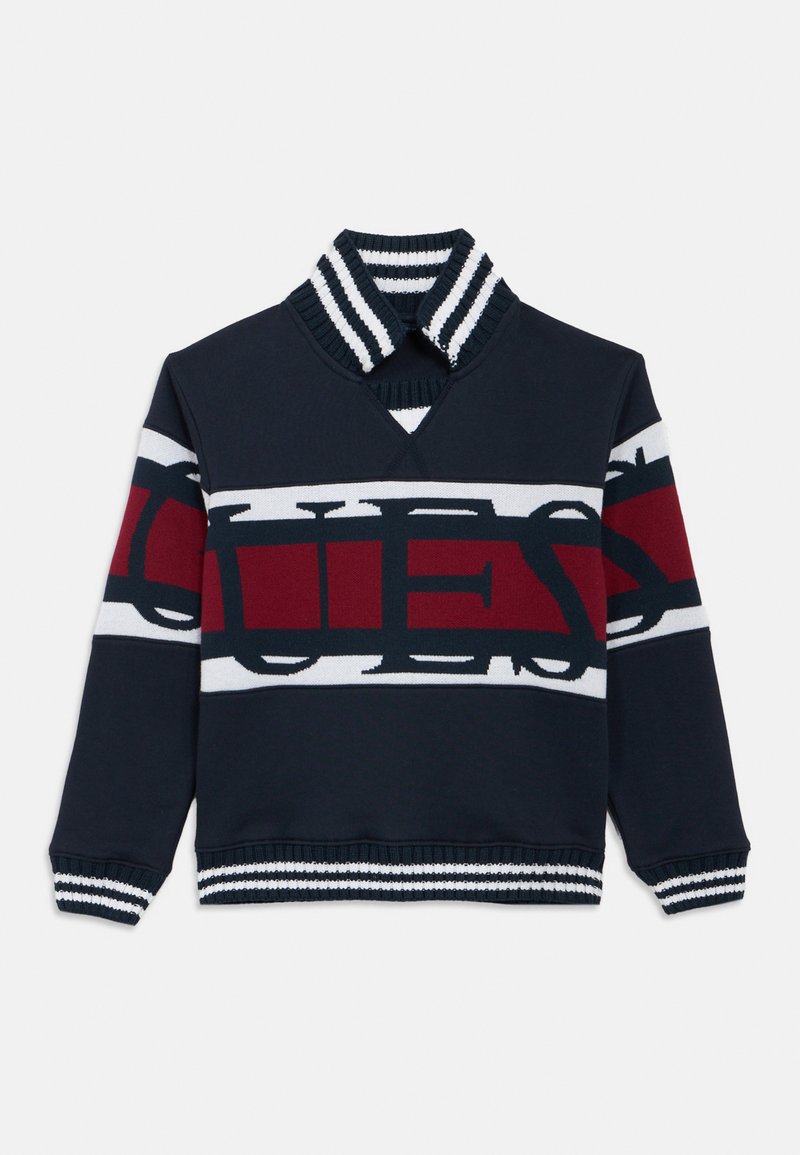 Μπλε ναυτικό φούτερ με ψηλό γιακά, με έντονο σχέδιο κόκκινων και λευκών ρίγων και εμφανείς γράμματα "QUE", καθώς και ριμπ μανσέτες.