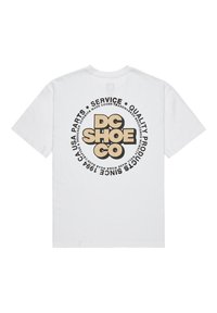 Camiseta de algodón blanca con un gráfico circular que presenta "DC SHOE CO" en texto negrita negro y beige, junto a otras frases relacionadas con servicios.