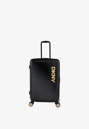 Maleta rígida negra con líneas diagonales en relieve, herrajes dorados, asa retráctil y cuatro ruedas giratorias para movilidad.