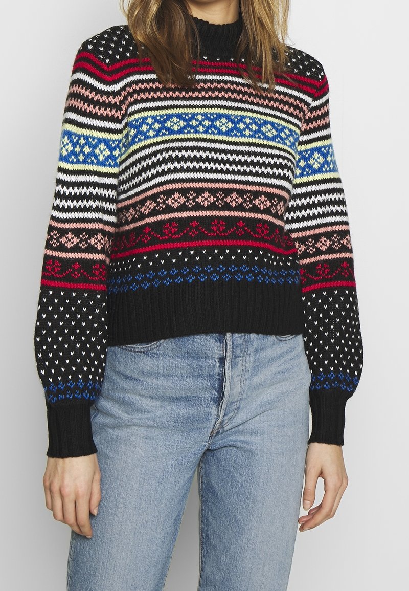 Färgglad stickad tröja med svart bas, med horisontella ränder i röd, rosa, blå och vit, samt ribbade ärmar och nederkant.