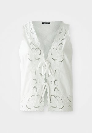 Weiße ärmellose Bluse mit floralen Spitzenausschnitten, gewellten Kanten und zwei vorderen Bindeschließen, vor einem schlichten Hintergrund.
