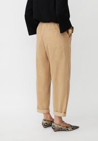 Beige, relaxed-fit corduroy broek met opgerolde cuffs en zijzakken, gecombineerd met puntige ballerina's met een slangenprint.
