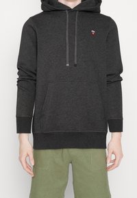 Donkere grijze hoodie met een kangoeroezak, capuchon met trekkoorden en geborduurd logo. Gemaakt van zachte stof, voorzien van geribbelde manchetten en zoom.