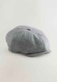 Szara wełniana czapka typu newsboy z zaokrągloną górą, ośmiopanelowym wzorze i krótkim, zakrzywionym daszkiem. Zszywane detale i akcent w postaci guzika na górze.