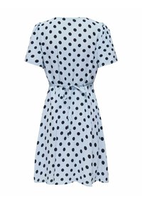 Robe bleu clair à manches courtes avec des pois noirs, dotée d'une ceinture nouée à la taille et d'un ourlet à hauteur du genou.