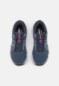 Baskets de sport bleu avec une tige en mesh, des superpositions synthétiques, une semelle intermédiaire blanche et des accents roses. Comprend des lacets ronds et une semelle texturée.