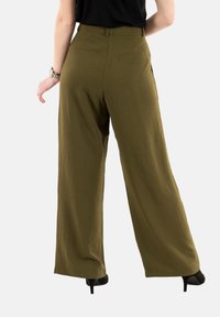 Pantaloni larghi color verde oliva realizzati in tessuto leggero. Presentano una vita alta, tasche posteriori e una superficie liscia.