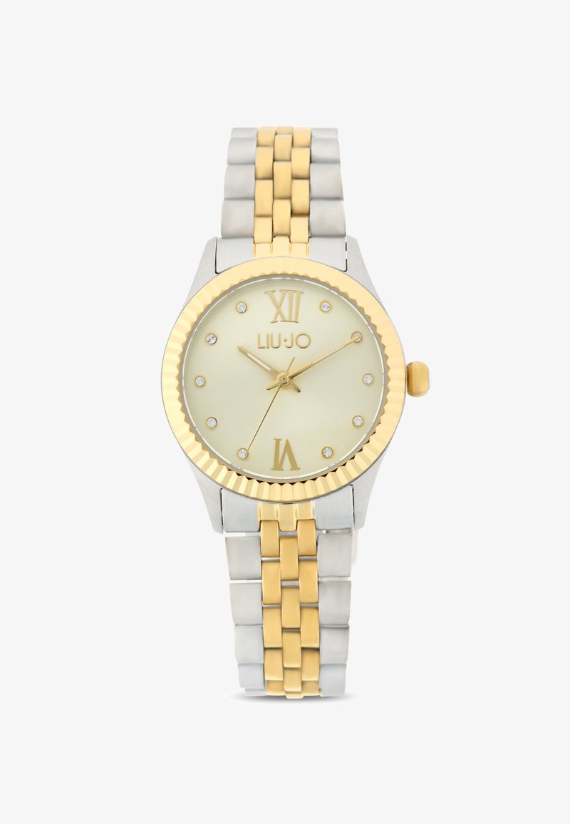 Orologio rotondo con un quadrante oro chiaro, cinturino in metallo bicolore oro e argento, numeri romani e indicatori delle ore in cristallo.