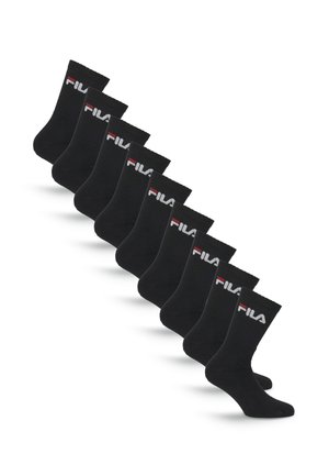 Dix paires de chaussettes noires type crew avec le logo FILA blanc et rouge près du haut, disposées en diagonale sur un fond blanc.
