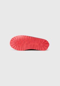 Suela negra de zapato con un fondo de goma roja texturizada que presenta patrones de relieve prominentes y crestas para un mejor agarre y durabilidad.
