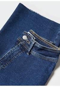 Jeans de mezclilla azul oscuro con un botón de metal visible y cremallera. Presentan costuras amarillas en contraste y un diseño doblado en la cintura.