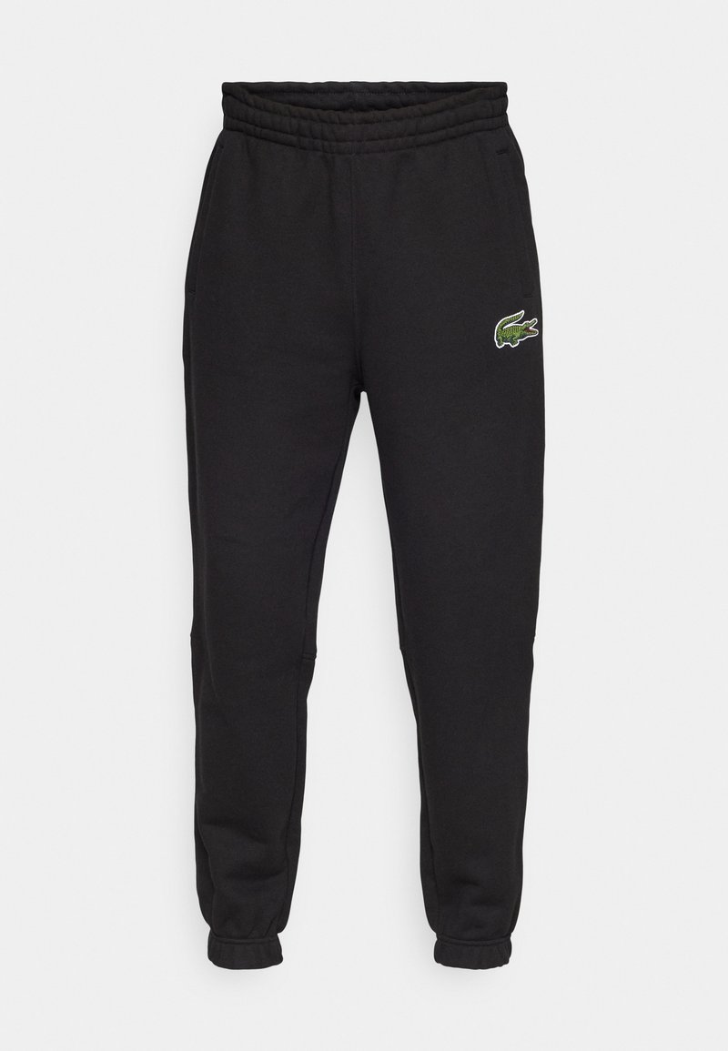 Schwarze Fleece-Jogginghosen mit elastischem Bund, gerippten Bündchen und einem grünen gestickten Krokodil-Logo am linken Bein.