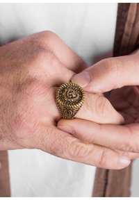 Inel auriu cu un spiralat complex și modele texturate. Banda prezintă accente detaliate, evidențiind măiestria și designul.