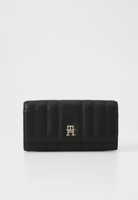 Black leather wallet with quilted design, gold hardware logo, and smooth texture. Features a flap closure and rectangular shape.