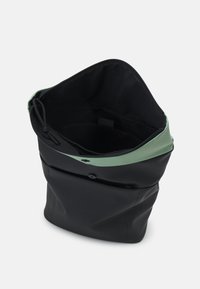 Svart väska med en grön överkant, tillverkad av ett slätt material. Innehåller ett blixtlås och en framficka med knappdetalj.