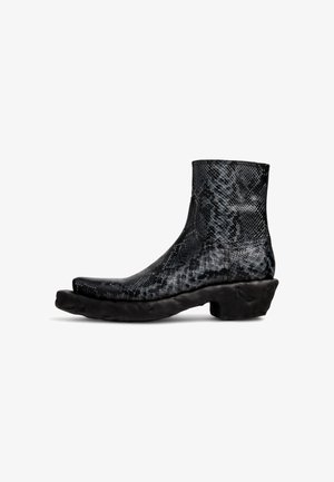 Zwarte enkellaarsjes met pythonprint, een gestructureerde bovenkant en een chunky zwarte rubberen zool. Beschikt over een ronde neus en een laag schachtontwerp.